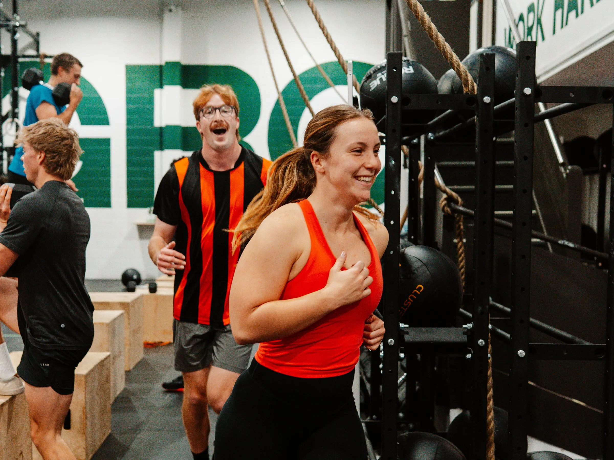 Members laughing mid-session in front of the green GRC wall.