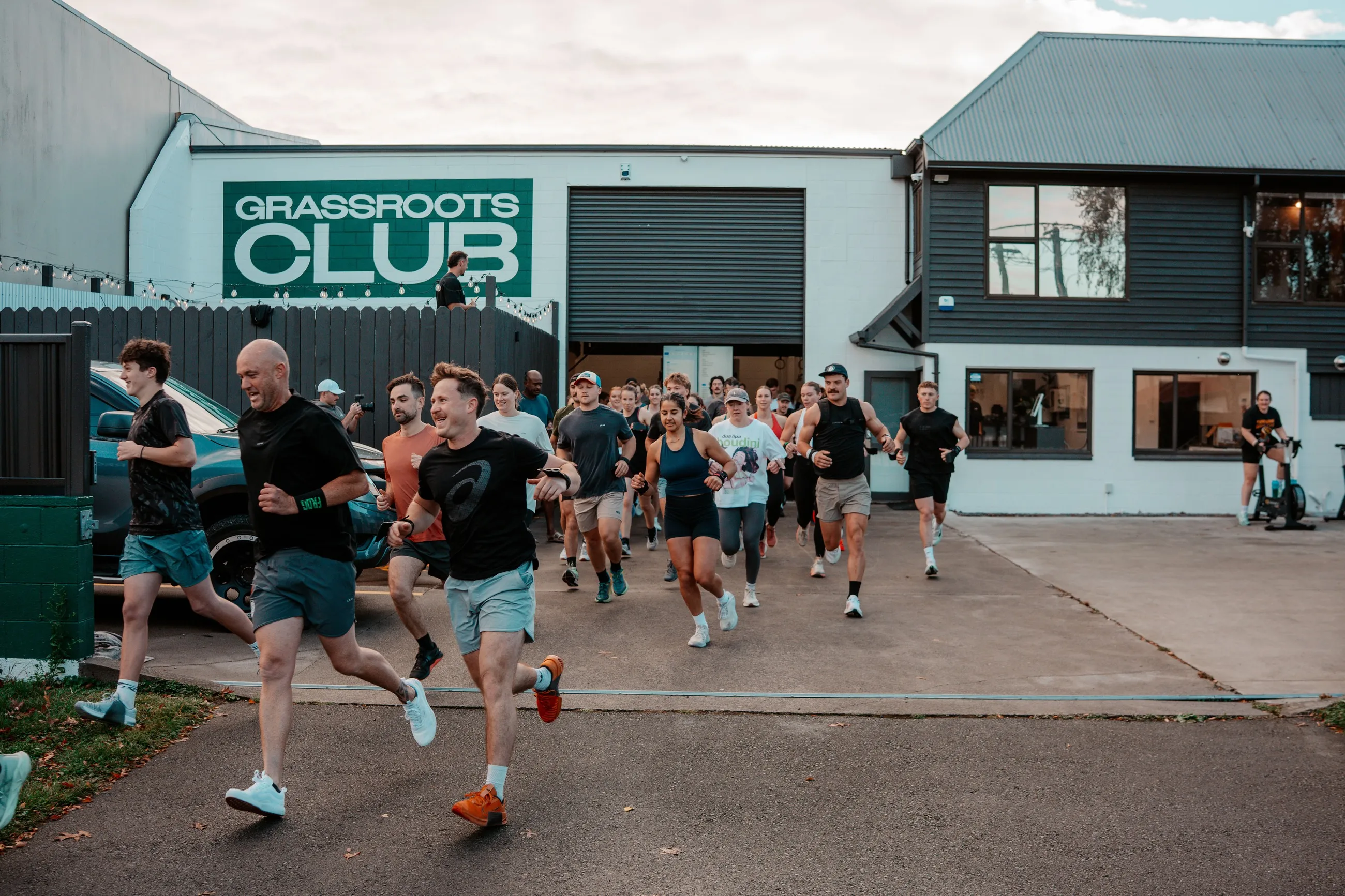 The whole club running out together under the Grassroots Club sign.