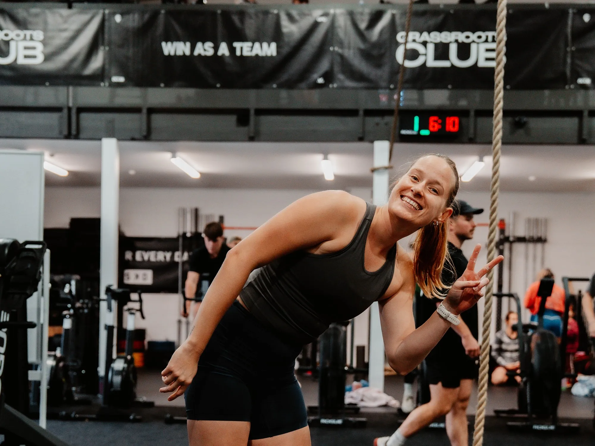 Two members laughing together mid-session under the “Win as a team” banner.